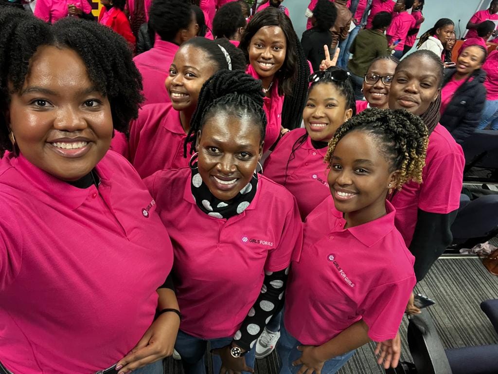 A group of girls posing for a photo whilst standing beside each other